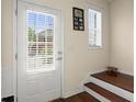 Bright entryway showcasing a white door with blinds, leading to stairs with dark wood treads at 2755 Greenbridge Dr, Norcross, GA 30071
