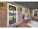 Inviting porch with brick flooring, seating area, and views of the front yard and neighborhood at 5917 Southland Dr, Stone Mountain, GA 30087