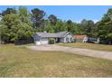 Single-story home featuring a wide driveway and a well-maintained front lawn at 1150 Bonita Cir, Jonesboro, GA 30238