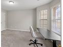 Bright bedroom featuring large windows, neutral carpet, and a functional desk area at 1439 Alice Ave, Lithonia, GA 30058