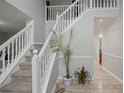 Inviting foyer features hardwood flooring, staircase with white railing and a plant at 1439 Alice Ave, Lithonia, GA 30058