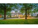Beautiful exterior of home with manicured lawn and shrubbery, mature trees, and lighted porch at 8109 Lawnview, Alpharetta, GA 30022