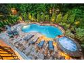 A backyard oasis featuring a gunite pool, hot tub, patio, lush landscaping, and comfortable seating at 8109 Lawnview, Alpharetta, GA 30022