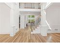 Elegant foyer featuring hardwood floors, white pillars, and a staircase with black iron railings at 8745 Islesworth Ct, Duluth, GA 30097