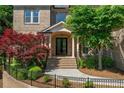 Inviting front entrance with brick stairs, decorative trees, and a black wrought iron fence at 8745 Islesworth Ct, Duluth, GA 30097