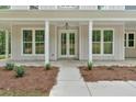 Elegant double doors lead to the entrance, surrounded by large windows and manicured landscaping at 12 Cedar Gate Ln, Kingston, GA 30145