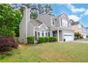 Lovely view of the exterior of the residence, including the manicured lawn, two-car garage, mature trees and inviting landscaping at 3381 Grovewood Ln, Duluth, GA 30096