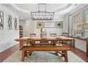 Formal dining room featuring elegant lighting, wainscoting, and a farmhouse-style table set at 4120 Winterberry Rd, Cumming, GA 30040