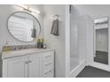 Modern bathroom featuring a marble vanity, round mirror, and a glass-enclosed shower with subway tile at 510 Edgewood Ne Ave # 6, Atlanta, GA 30312