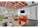 Stylish living room showcasing a comfortable sofa, bold orange chair, large windows, and exposed ceiling beams at 510 Edgewood Ne Ave # 6, Atlanta, GA 30312