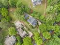 Stunning aerial view of a luxurious home nestled among lush greenery, showcasing its well-manicured yard at 3642 River Club Dr, Cumming, GA 30041