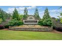 Elegant stone entrance to the Chattahoochee River Club community with manicured landscaping and decorative flowers at 3642 River Club Dr, Cumming, GA 30041