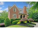 Well-maintained brick house showcasing manicured landscaping, mature trees and manicured lawn at 3642 River Club Dr, Cumming, GA 30041