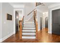 Bright foyer features hardwood floors, a staircase with wood railing, and neutral paint at 3642 River Club Dr, Cumming, GA 30041