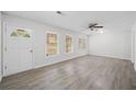 Bright living room with gray floors, ceiling fan, and a front door with sidelight windows at 9 Latimer Rd, Cartersville, GA 30121