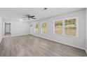 Inviting living room with gray flooring, three windows, and a modern ceiling fan at 9 Latimer Rd, Cartersville, GA 30121