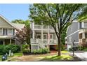 Charming two-story home featuring a welcoming front porch, mature tree, and lovely landscaping at 1626 Gilstrap Nw Ln, Atlanta, GA 30318