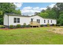 Inviting single-story home with white siding, landscaping, and a lovely front lawn at 1960 W Hightower Trl, Conyers, GA 30012