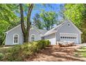 Beautiful one-story home with a large tree, a two-car garage, and attractive architectural details at 1965 Tiner Ct, Cumming, GA 30041