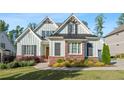 Inviting two-story home with light-gray siding, brick accents, manicured lawn, and beautiful landscaping at 2208 Sage Mountain Sw Ct, Marietta, GA 30064