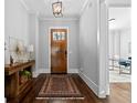 Elegant foyer featuring hardwood floors, wooden front door, console table, and view into office space at 2208 Sage Mountain Sw Ct, Marietta, GA 30064
