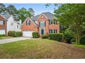 Beautiful two-story brick home with dark blue shutters, a well-maintained lawn, and a long driveway at 7035 Hampton Bluff Way, Roswell, GA 30075