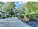 Long driveway leading to a charming craftsman home surrounded by trees and landscaping at 975 Timber Lake Trl, Cumming, GA 30041