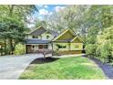 Craftsman-style home featuring a manicured lawn, stone accents, and lush greenery at 975 Timber Lake Trl, Cumming, GA 30041