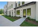 Exterior view of a white brick townhome featuring a black awning and dark-framed windows at 2202 Carlton Ct # 7, Atlanta, GA 30318
