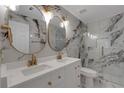 Modern bathroom featuring double vanity, decorative mirrors, and a glass enclosed shower at 1095 Lyndhurst Way, Roswell, GA 30075
