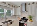 Bright kitchen with stainless steel appliances, white cabinets, and a large sink under the window at 1095 Lyndhurst Way, Roswell, GA 30075