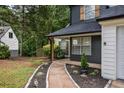 Home's inviting pathway leading to a covered entry, accentuated with black accents, offers a warm welcome at 1930 Rocky Mill Ln, Lawrenceville, GA 30044