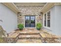 Elegant stone entryway with double doors and manicured landscaping, creating a welcoming entrance at 1152 Ward Creek Sw Dr, Marietta, GA 30064