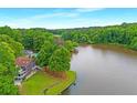Aerial view of lakefront property with a spacious house and lush surrounding greenery at 160 Old Mill Ct, Fayetteville, GA 30214