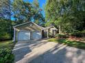 Charming single-story home with a two-car garage, landscaped front yard, and a driveway at 2160 Towne Manor Nw Dr, Kennesaw, GA 30144