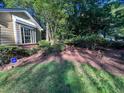 Landscaped front yard features a brick garden bed with lush green bushes and beautiful red roses at 2160 Towne Manor Nw Dr, Kennesaw, GA 30144