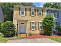 Charming two-story home with yellow siding, green shutters, and a well-manicured front yard at 4120 Buckley Woods Dr, Norcross, GA 30093