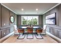 Elegant dining room featuring stylish paneling, modern lighting, and a large window with a scenic view at 5121 Hillside Haven Drive, Powder Springs, GA 30127