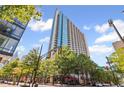 An exterior of the condo tower with lush trees and clear blue skies at 860 Peachtree Ne St # 1712, Atlanta, GA 30308