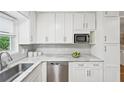 Well-lit kitchen featuring stainless steel appliances, marble countertops, and stylish white cabinets at 1118 Creekdale Dr, Clarkston, GA 30021