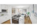 Modern kitchen boasts a large island with a gas range and marble countertops, open to the dining area at 1118 Creekdale Dr, Clarkston, GA 30021