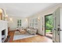 Bright living room with hardwood floors, shutters, fireplace and a view to the outside, complemented with neutral decor at 96 Dartmouth Ave, Avondale Estates, GA 30002
