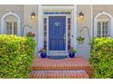 Inviting entryway with a blue front door, brick steps and colorful potted plants at 222 Mossy Pl, Alpharetta, GA 30005