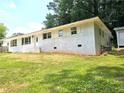 A charming white brick ranch-style home with a lush green front lawn, and white trim at 345 Forest Valley Rd, Lawrenceville, GA 30046