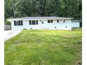 Charming white brick ranch-style home with lush green front lawn and concrete driveway at 345 Forest Valley Rd, Lawrenceville, GA 30046
