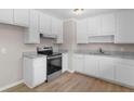 Well-equipped kitchen featuring white cabinets, modern appliances, and granite countertops at 10116 Straphinge Trl, Covington, GA 30014