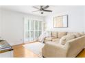 Cozy living room featuring a comfortable beige sofa, ceiling fan, and sliding door to a balcony at 6204 Santa Fe Pkwy, Atlanta, GA 30350