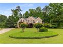 Stunning brick home featuring a pristine lawn, mature trees, and meticulously manicured landscaping at 2759 Thomashire Trce, Marietta, GA 30066