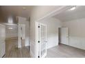 Bright entryway with white trim, light wood floors, and decorative French doors leading to additional rooms at 900 Ellesmere Pt, Mcdonough, GA 30253