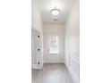 Well-lit hallway with white trim, light wood floors, and a glass-paneled back door for natural light at 900 Ellesmere Pt, Mcdonough, GA 30253